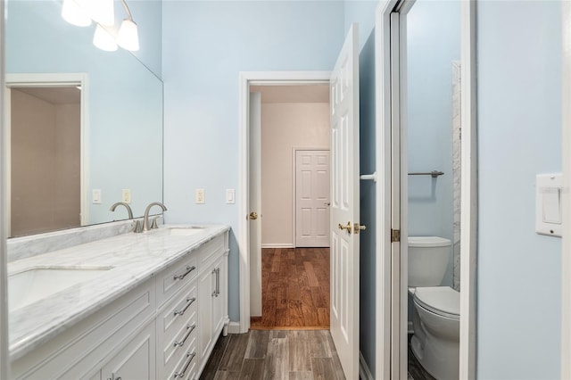 bathroom with vanity, hardwood / wood-style flooring, and toilet