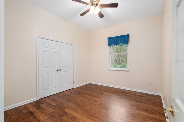 unfurnished bedroom featuring dark hardwood / wood-style flooring, ceiling fan, and a closet