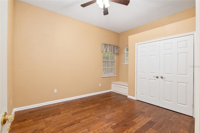 unfurnished bedroom featuring ceiling fan, a closet, and dark hardwood / wood-style flooring