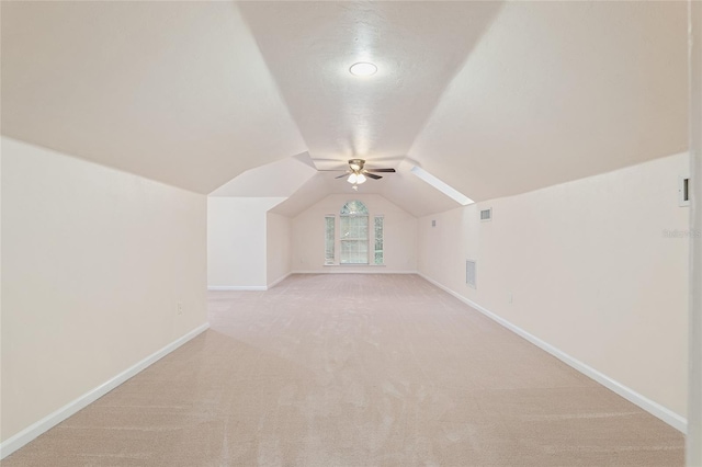 bonus room with light carpet and vaulted ceiling