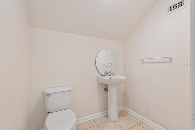 bathroom with tile patterned floors, toilet, and lofted ceiling