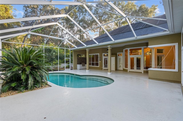 view of pool featuring glass enclosure, french doors, a patio, and ceiling fan