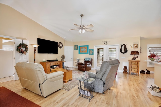 living room with ceiling fan, vaulted ceiling, light hardwood / wood-style floors, and french doors