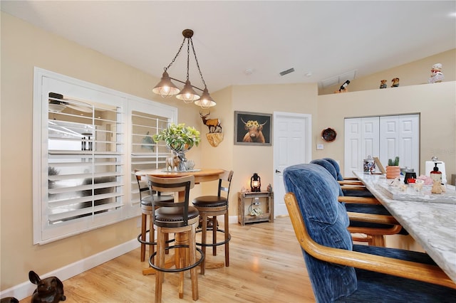 dining space featuring light hardwood / wood-style floors and vaulted ceiling