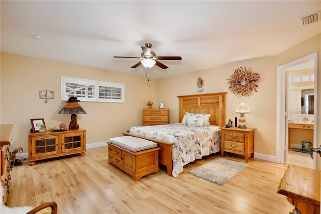 bedroom featuring light hardwood / wood-style floors, ceiling fan, and ensuite bathroom