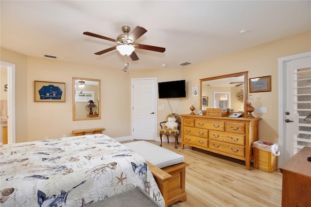 bedroom with light wood-type flooring, ceiling fan, and ensuite bath