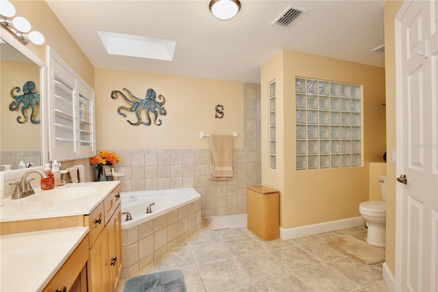 bathroom featuring a skylight, a textured ceiling, tile patterned floors, and vanity