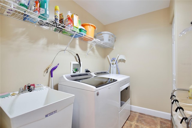 laundry room featuring washing machine and dryer, sink, and light tile patterned flooring