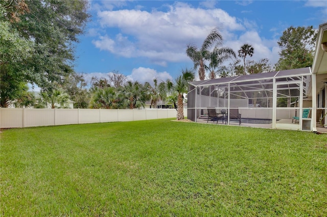 view of yard with glass enclosure and a patio