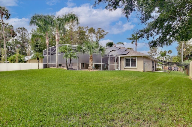 rear view of property with a lawn and glass enclosure