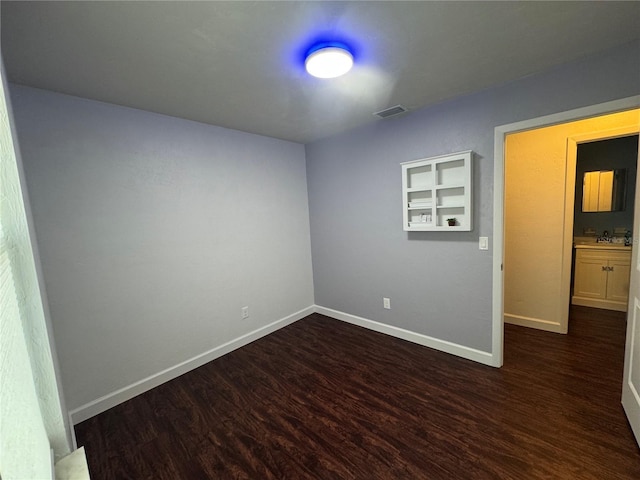 unfurnished room featuring dark wood-style floors and baseboards