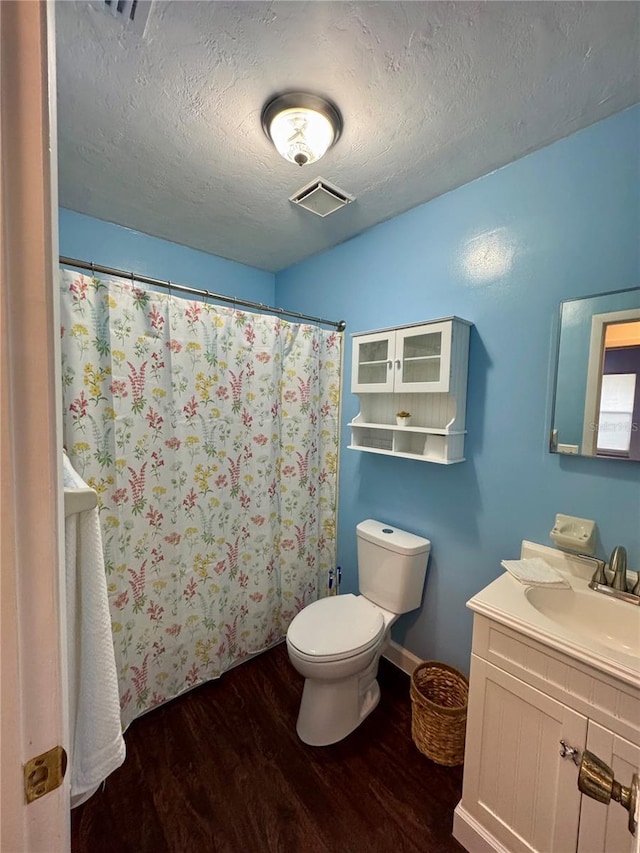 full bathroom featuring wood finished floors, a textured ceiling, toilet, vanity, and a shower with shower curtain