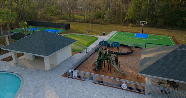 view of pool featuring basketball hoop and a playground