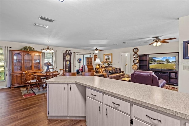 kitchen with a wealth of natural light, dark hardwood / wood-style floors, and hanging light fixtures