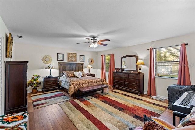 bedroom with multiple windows, light hardwood / wood-style flooring, and ceiling fan