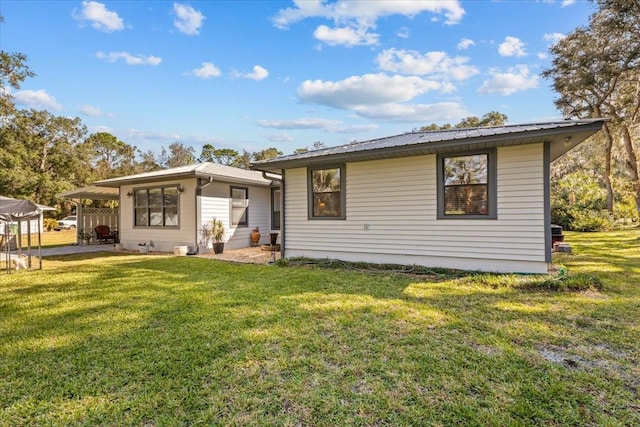 back of house featuring a lawn and a patio