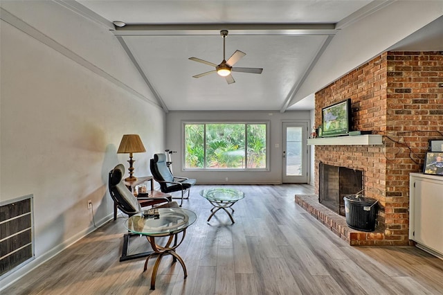 living room featuring ceiling fan, heating unit, a fireplace, wood-type flooring, and lofted ceiling with beams