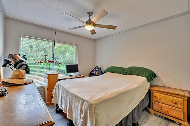 bedroom featuring multiple windows, wood-type flooring, ceiling fan, and crown molding