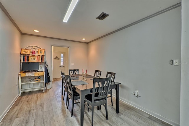 dining room featuring ornamental molding and light wood-type flooring