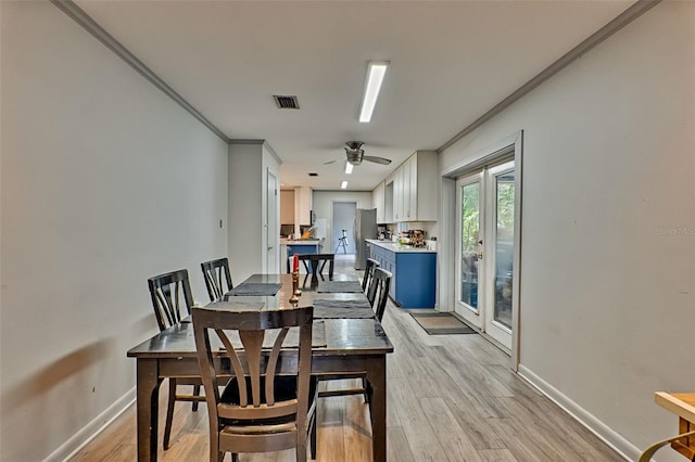 dining space featuring ceiling fan, light hardwood / wood-style flooring, and crown molding