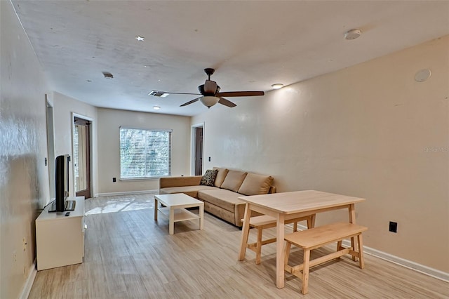 living room featuring ceiling fan and light wood-type flooring