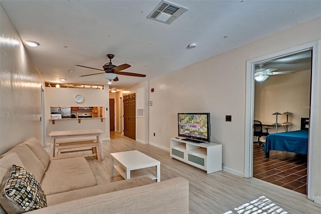 living room featuring wood-type flooring and ceiling fan