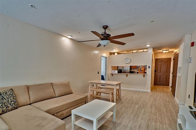 living room featuring light hardwood / wood-style flooring and ceiling fan