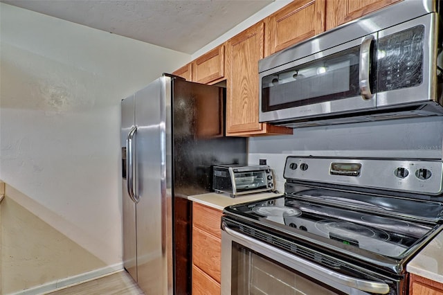 kitchen with light wood-type flooring and stainless steel appliances