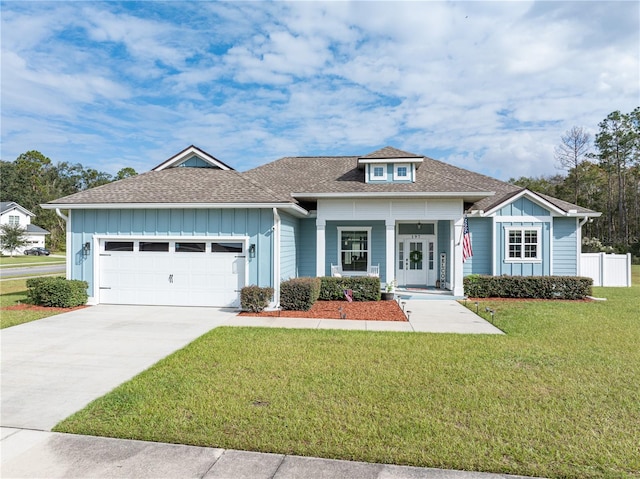 view of front of house featuring a front yard, a porch, and a garage