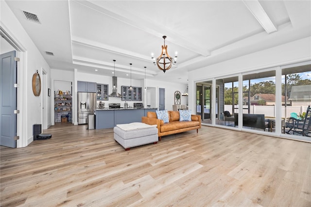 unfurnished living room with a chandelier, a tray ceiling, light hardwood / wood-style flooring, and beamed ceiling