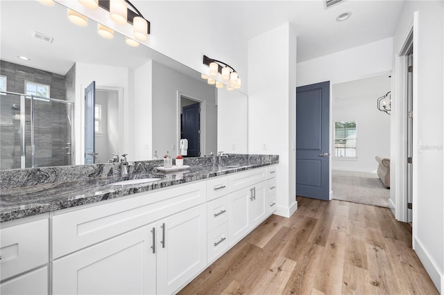 bathroom featuring vanity, hardwood / wood-style flooring, and an enclosed shower