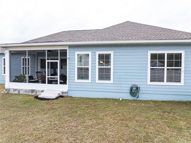 rear view of house with a yard and a sunroom