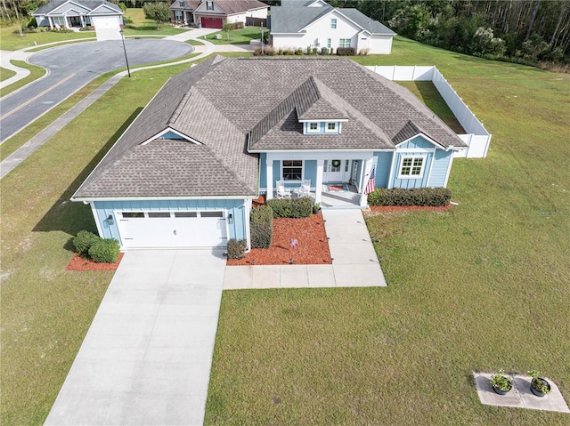 view of front of house featuring a front lawn, a porch, and a garage