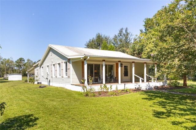 rear view of house featuring a lawn and covered porch