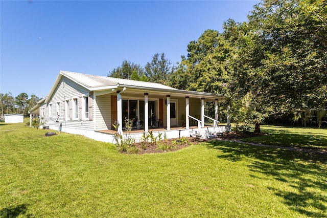 back of property featuring a lawn and covered porch