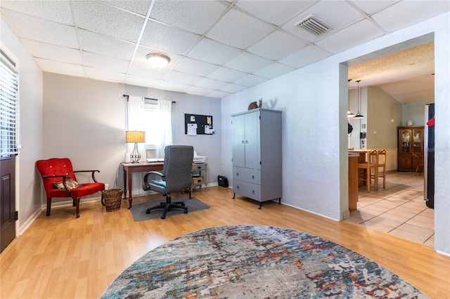 home office featuring hardwood / wood-style flooring, plenty of natural light, and a paneled ceiling