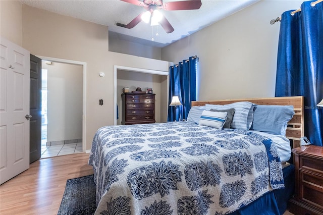 bedroom with light wood-type flooring, a textured ceiling, and ceiling fan