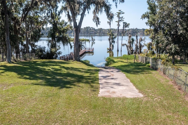 dock area featuring a water view and a lawn