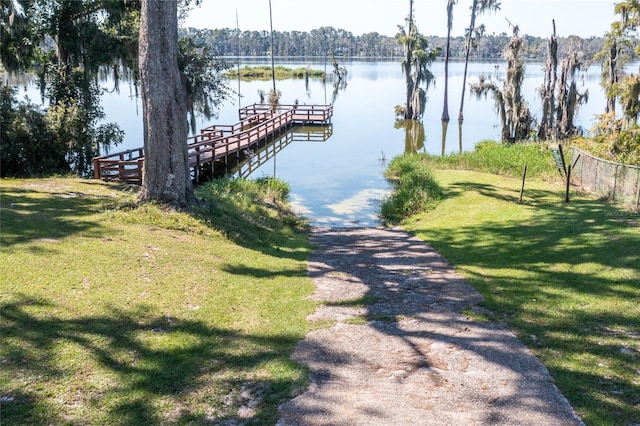 view of dock featuring a water view and a lawn