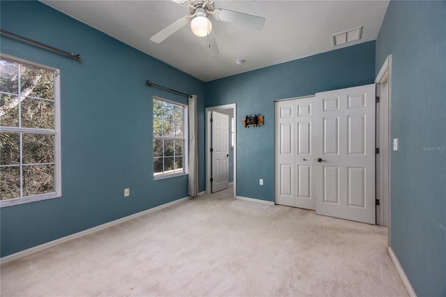 unfurnished bedroom featuring light colored carpet and ceiling fan