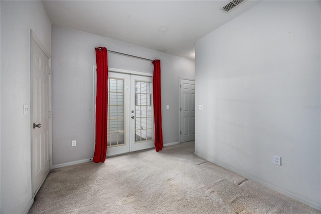 carpeted empty room featuring french doors