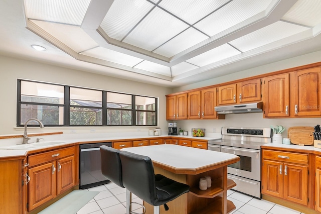 kitchen featuring a kitchen breakfast bar, stainless steel appliances, sink, a kitchen island, and light tile patterned flooring