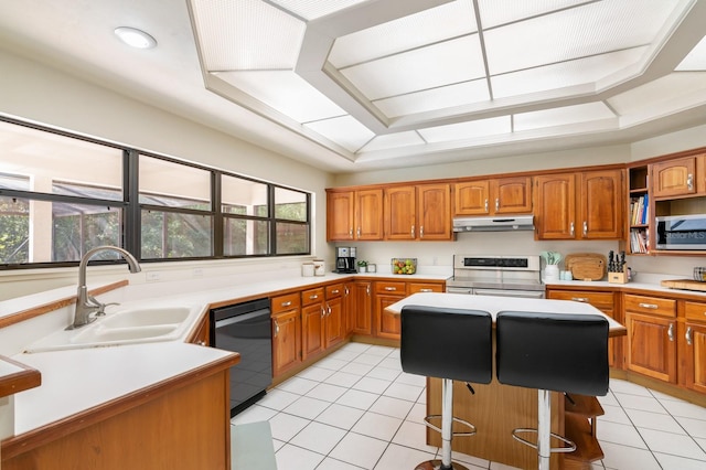 kitchen with sink, stainless steel appliances, a raised ceiling, a breakfast bar, and light tile patterned floors