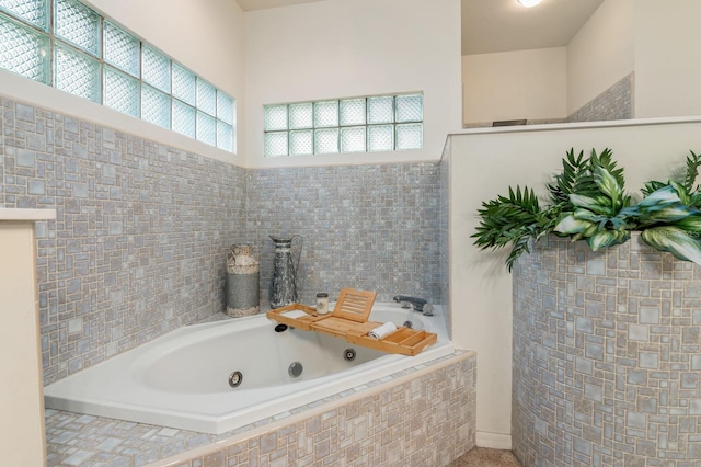 bathroom featuring tile walls and tiled tub