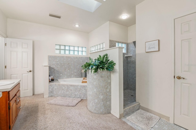 bathroom featuring vanity, a skylight, and separate shower and tub