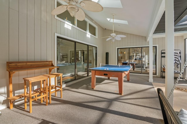 rec room featuring carpet, ceiling fan, high vaulted ceiling, and a skylight