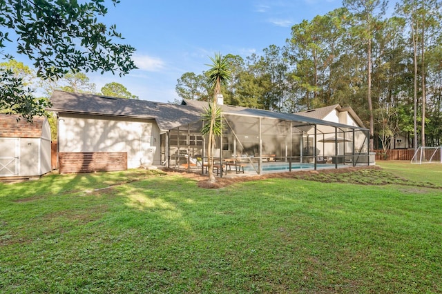 rear view of property featuring a yard, a storage shed, and a lanai