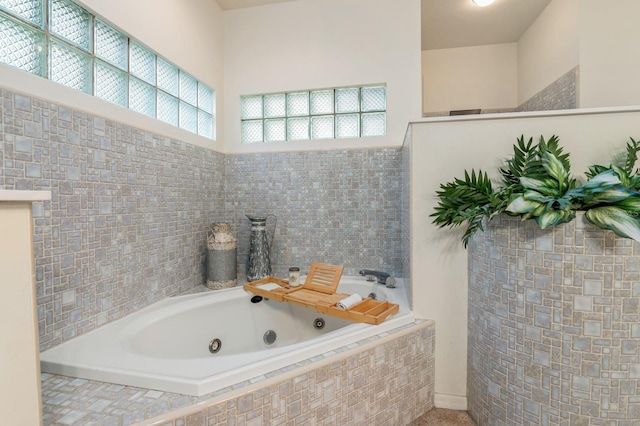 bathroom featuring tiled bath and plenty of natural light