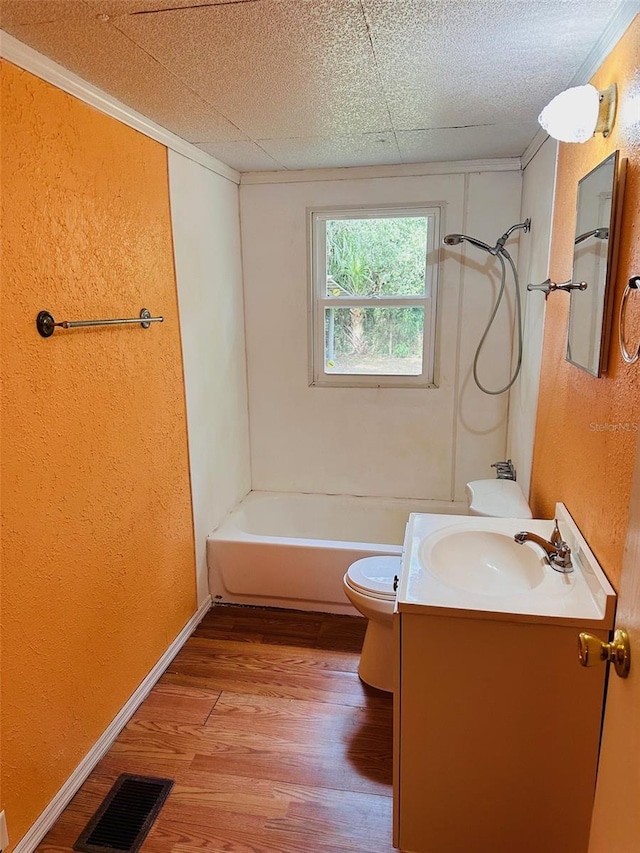 full bathroom featuring ornamental molding, vanity,  shower combination, hardwood / wood-style flooring, and toilet