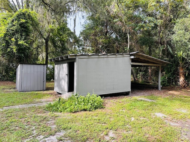 view of outdoor structure featuring a carport and a lawn